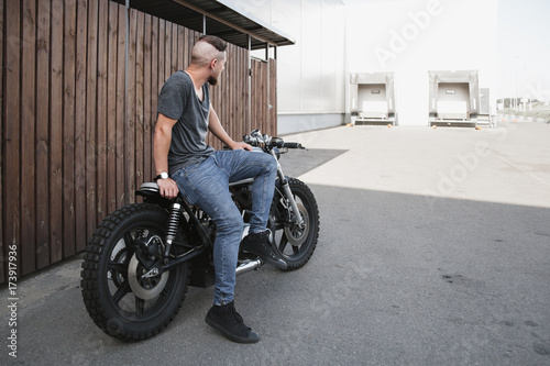 Rider guy with classic style cafe racer motorcycle photo