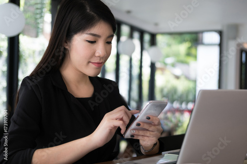 businesswoman use mobile phone at workplace. young woman texting message on smart phone at office. freelancer use cellphone for online network connection at cafe coffee shop.