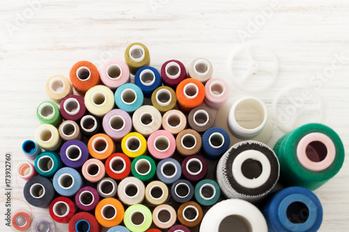Background of colorful sewing threads on white table