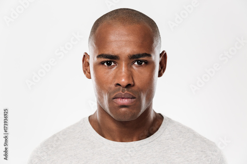 Serious young african man standing isolated