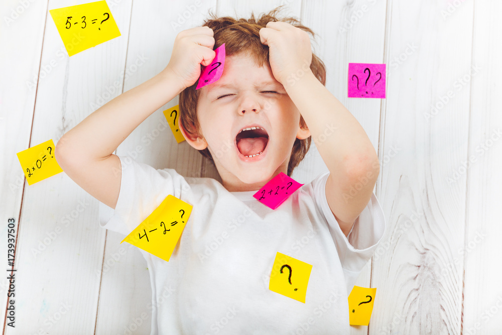 Foto de Crying child with question symbol with stickers on his head and ...