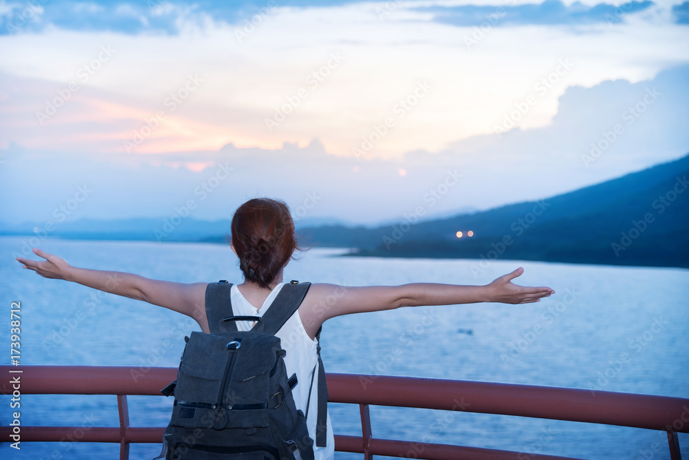 Happy Young Asian backpacker woman relaxing on sea and sunset sky background. Happy Young Asian backpacker woman relaxing on sea and sunset sky background.