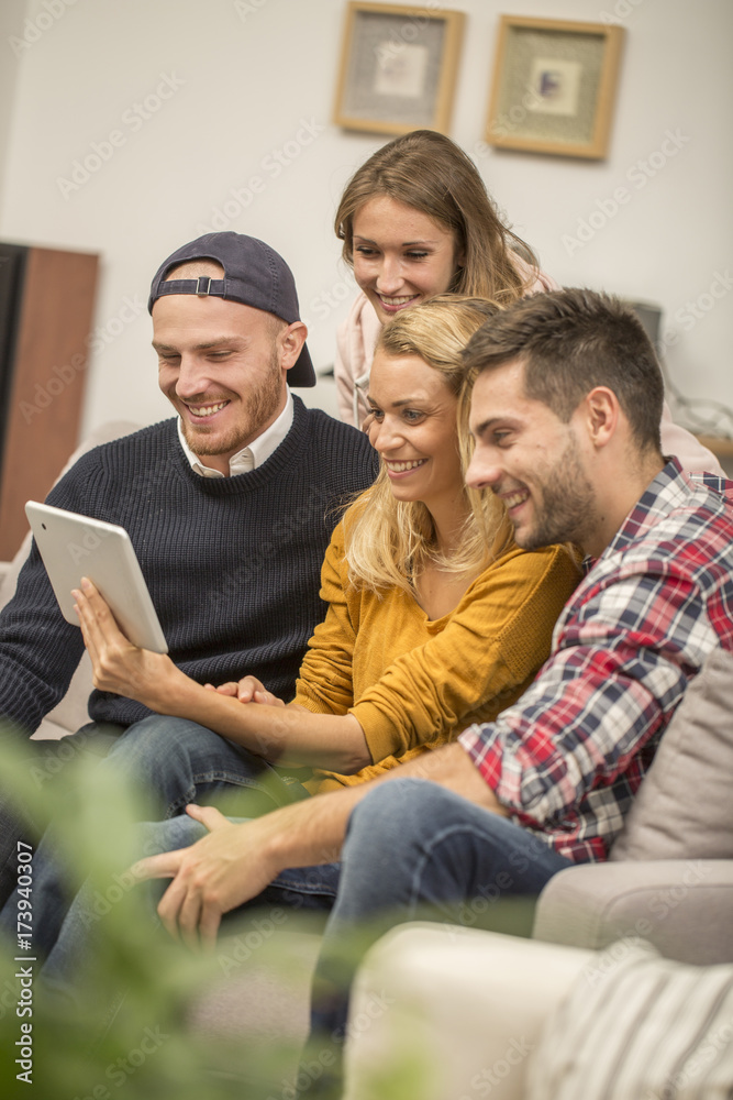 roommates choosing tv program on digital tablet