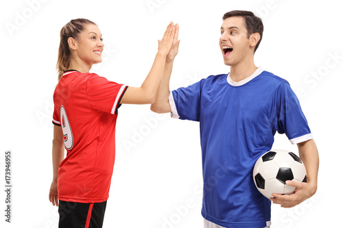 Female and a male soccer player high-fiving each other