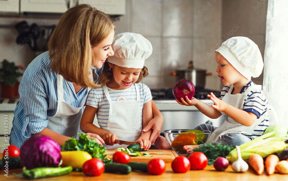 Healthy eating. Happy family mother and children  prepares   vegetable salad