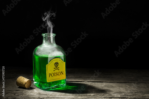 The poison is a green liquid in a glass vial. A deadly potion with a skull and bones on the label. Copy space for text. 3D rendering photo