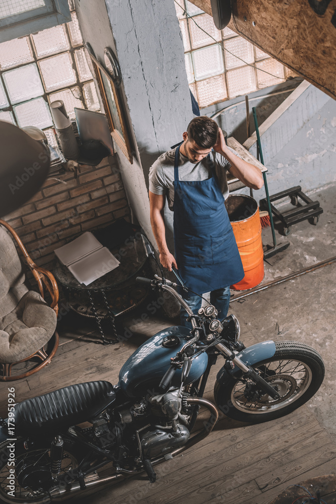 mechanic with motorbike in garage