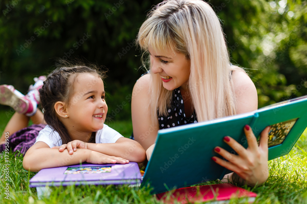 Mother and daughter reading a book at the park. Mother and daughter reading a book at the park.