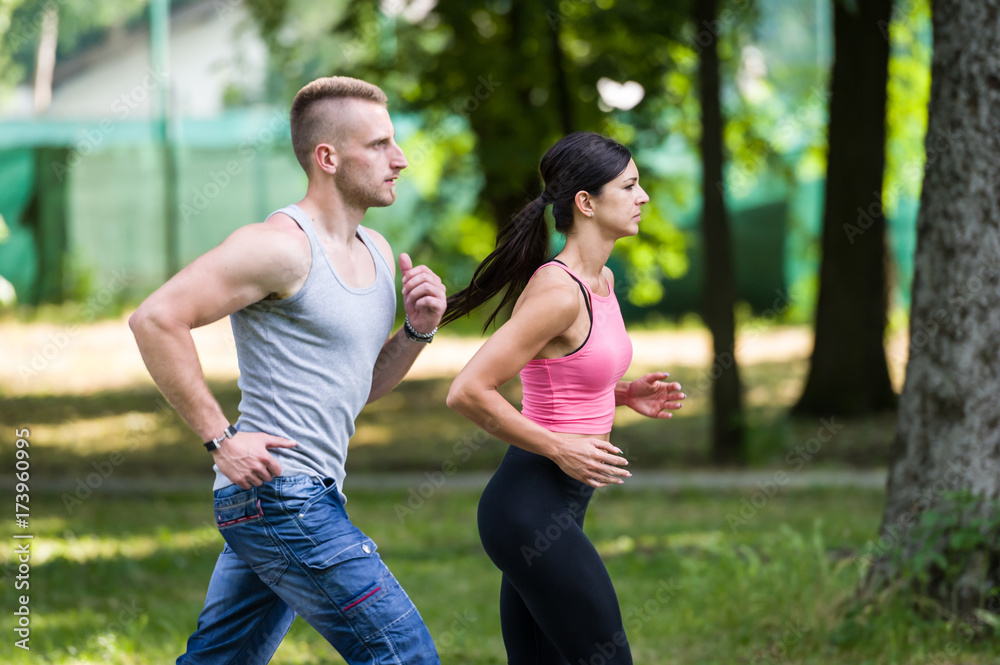 sport woman and man running together in a park in summer sport woman and man running together in a park in summer