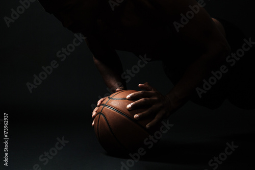 Cropped photo of afro american basketball player,  doing pushup exercise on the ball © Drobot Dean