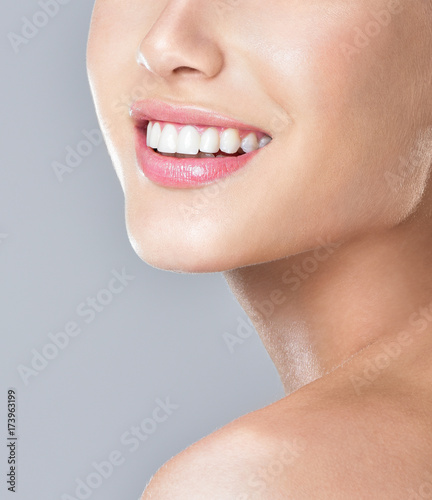 Beautiful face of young adult woman with clean fresh skin. Amazing smile, perfect teeth.