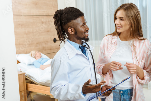 Young doctor talking to woman photo