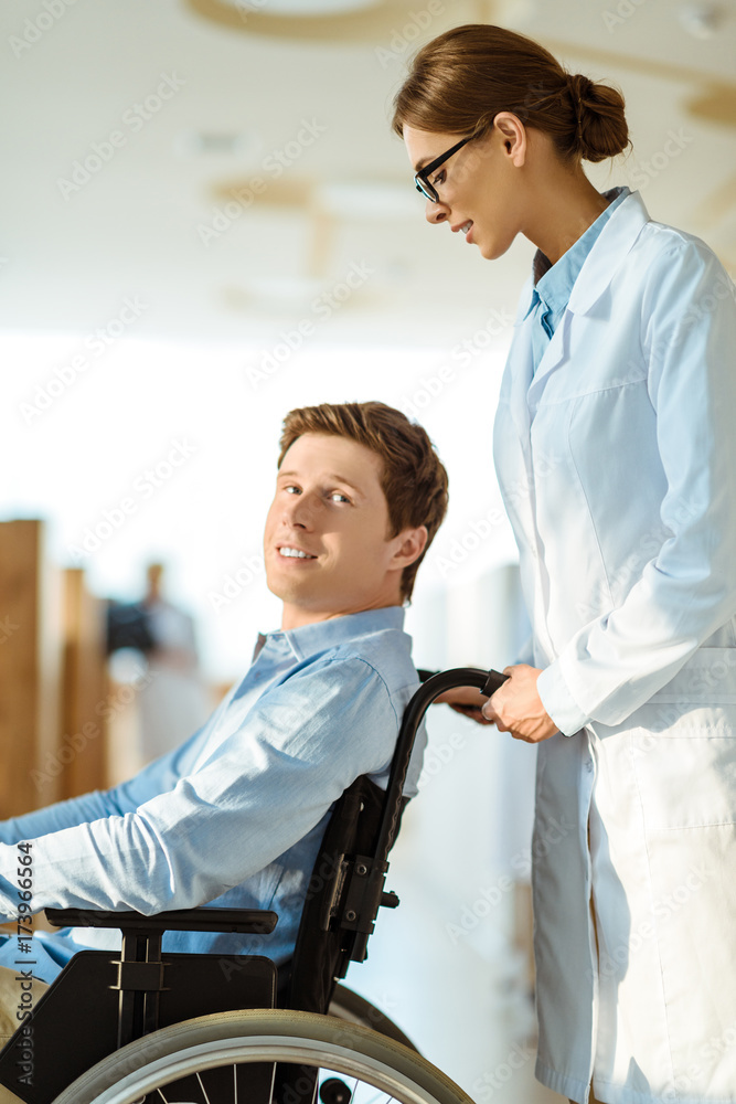 Obraz premium doctor rolling man in wheelchair