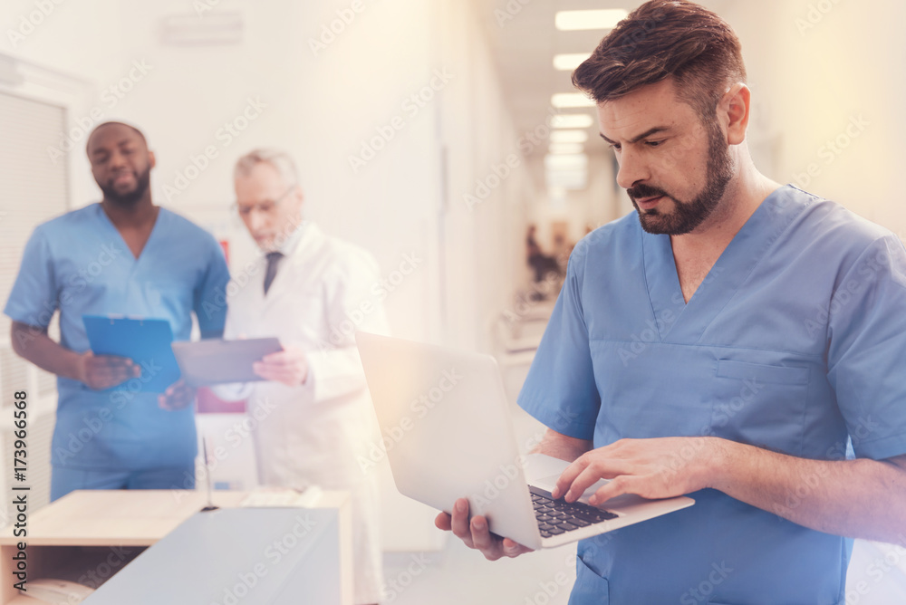 Serious bearded brunette working with laptop Serious bearded brunette working with laptop