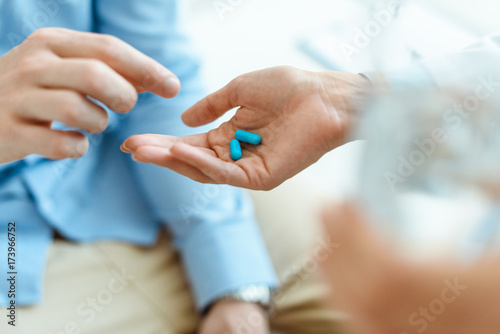 man taking pills from hand
