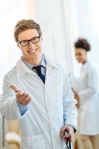 Smiling doctor holding out hand