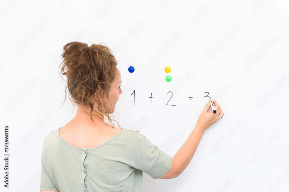 teacher woman teaches how to count on whiteboard in the classroom teacher woman teaches how to count on whiteboard in the classroom