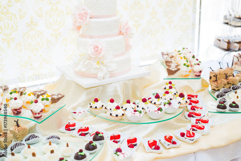 Delicious and tasty dessert table with cupcakes shots at reception closeup Delicious and tasty dessert table with cupcakes shots at reception closeup
