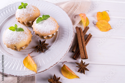 Autumn pastries. Homemade cupcakes with powdered sugar with cinnamon sticks, anise stars and autumn leaves