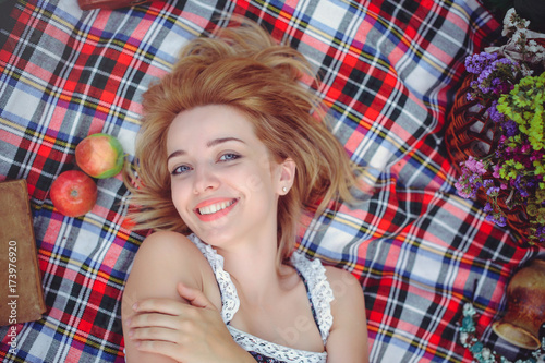 young woman lies with apple on picnic, healthy lifestyle, happy