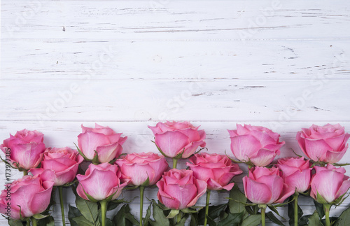 Fototapeta Naklejka Na Ścianę i Meble -  Pink roses flowers on white wooden background with copy space. Top view..Pink roses flowers on white wooden background with copy space. Top view..