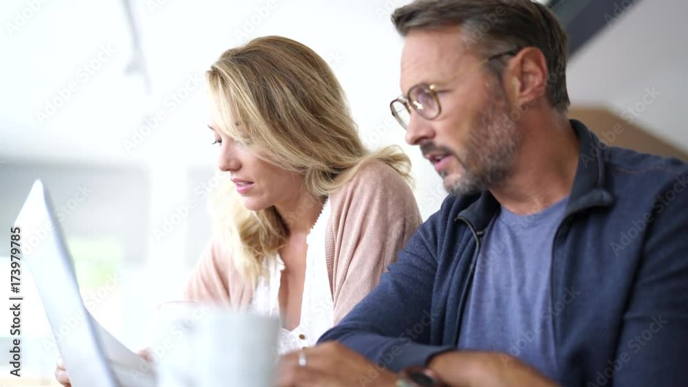 Mature couple at home working on laptop computer Mature couple at home working on laptop computer