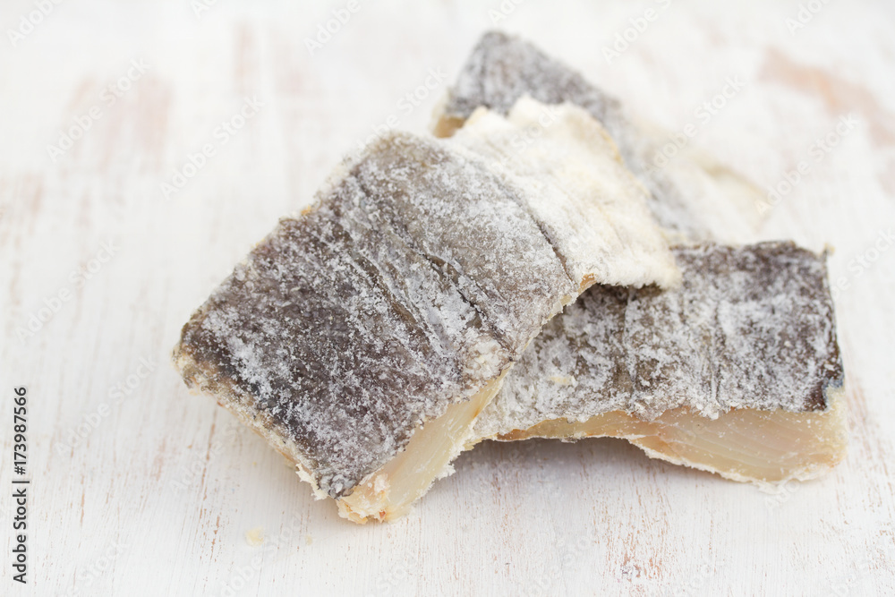 salted dry codfish on white wooden background
