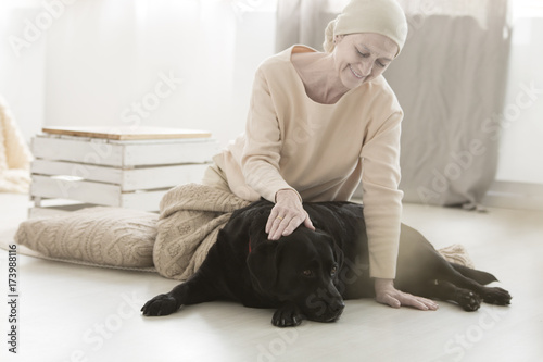 Senior sick woman stroking dog © Photographee.eu