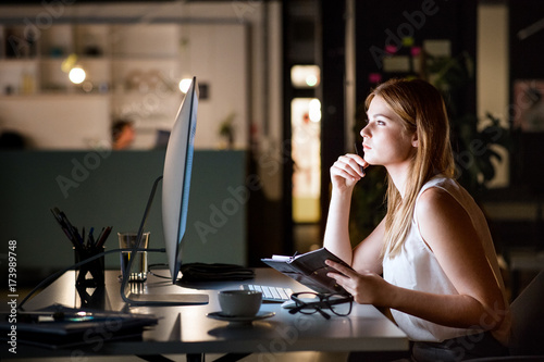 Businesswoman in her office at night working late.