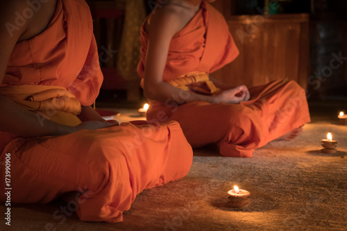 Novices monk vipassana meditation in front lighting candle photo