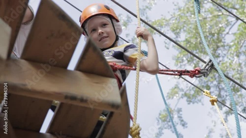 Wallpaper Mural Little cute boy enjoying activity in a climbing adventure park on a summer sunny day. toddler climbing in a rope playground structure. Safe Climbing extreme sport with helmet and Carabiner. insurance Torontodigital.ca
