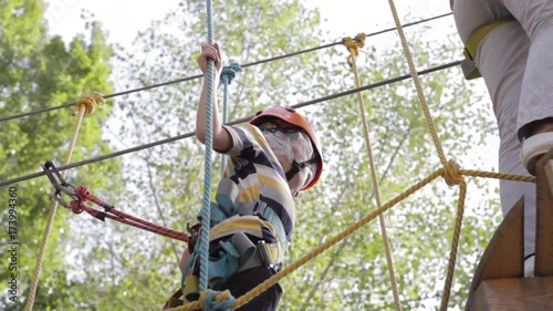 Wallpaper Mural Little cute boy enjoying activity in a climbing adventure park on a summer sunny day. toddler climbing in a rope playground structure. Safe Climbing extreme sport with helmet and Carabiner. insurance Torontodigital.ca
