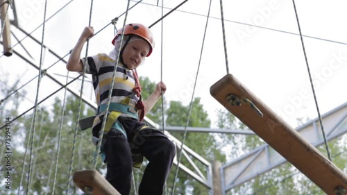 Wallpaper Mural Little cute boy enjoying activity in a climbing adventure park on a summer sunny day. toddler climbing in a rope playground structure. Safe Climbing extreme sport with helmet and Carabiner. insurance Torontodigital.ca