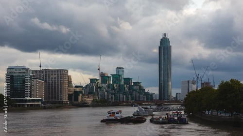 London Time-Lapse,  St George Wharf Tower with blue clouds and the yellow river Thames at sunset.
Zoom in. photo