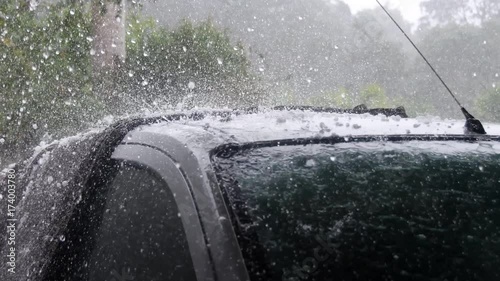 Hail stones pelting roof of car during violent storm photo