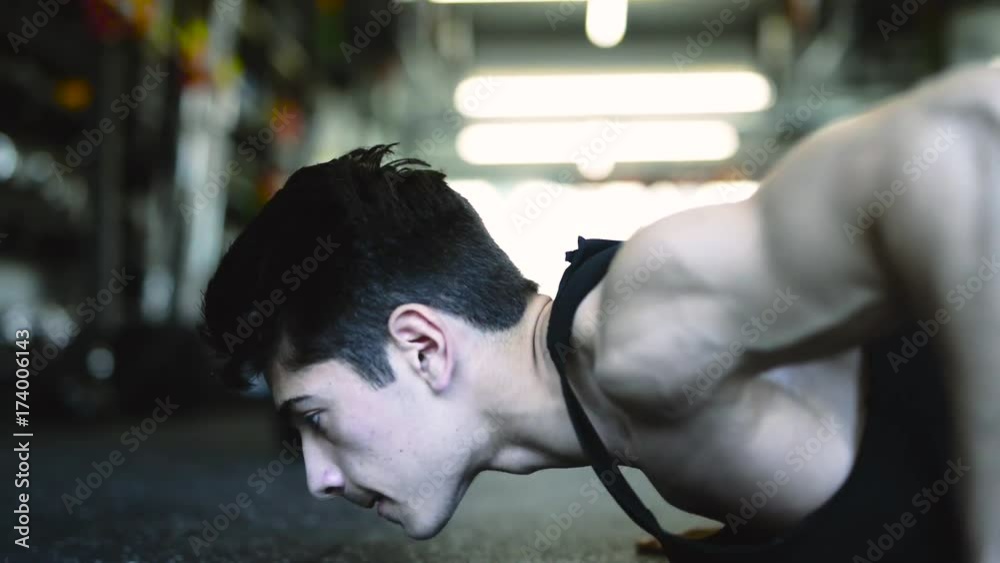 Young fit man in gym doing push ups. Young fit man in gym doing push ups.