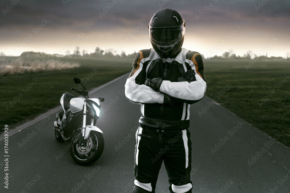 Naklejka premium Motocyklista stoi na wiejskiej drodze