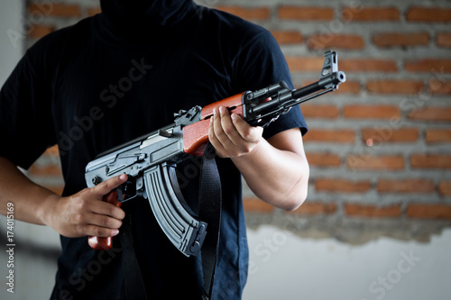 Midsection of man holding rifle outdoors