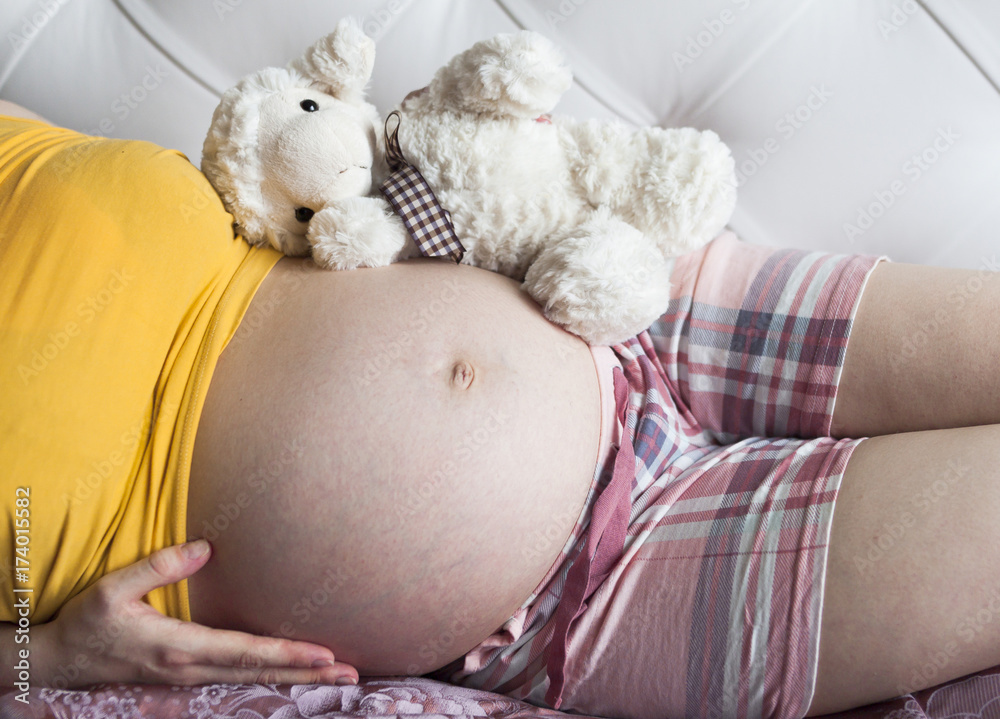 Belly of a pregnant woman with toy