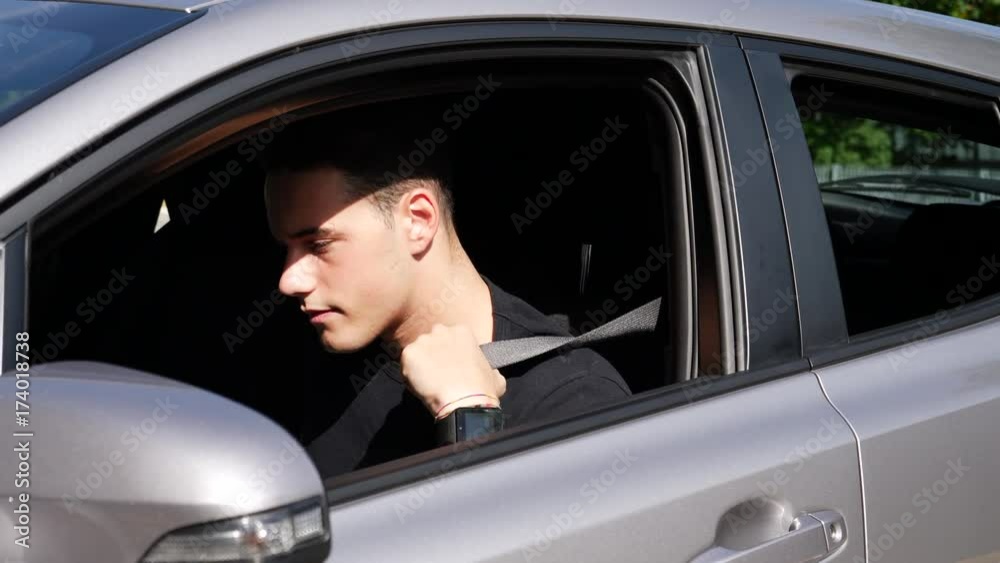 Young handsome man getting on his car then fastening seat belt for his safety, just about to turn the engine on Young handsome man getting on his car then fastening seat belt for his safety, just about to turn the engine on