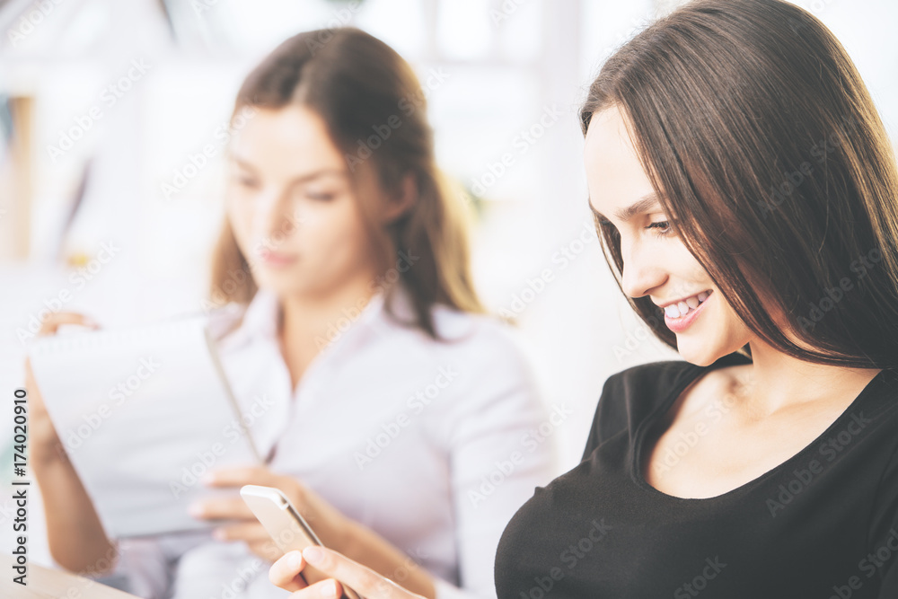 Women with notepad and smartphone Women with notepad and smartphone