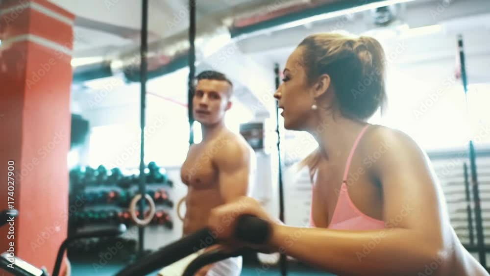 Fit couple on cycling machines doing exercise together at gym Fit couple on cycling machines doing exercise together at gym
