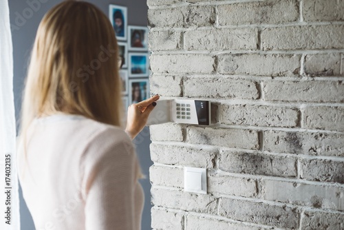 Obraz na płótnie Woman entering pin on home alarm w salonie