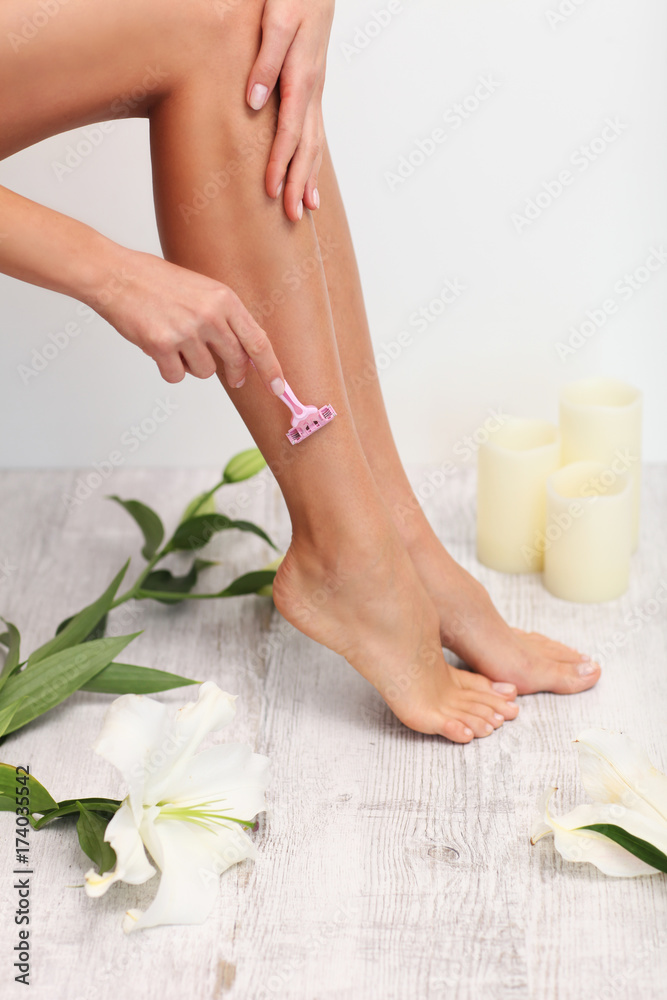 Woman is shaving her legs.