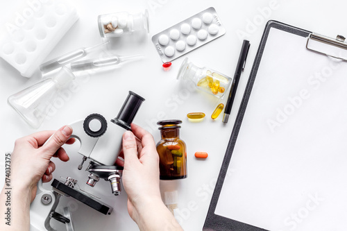 Do medcal tests. Hands hold microscope on white background top view mockup photo