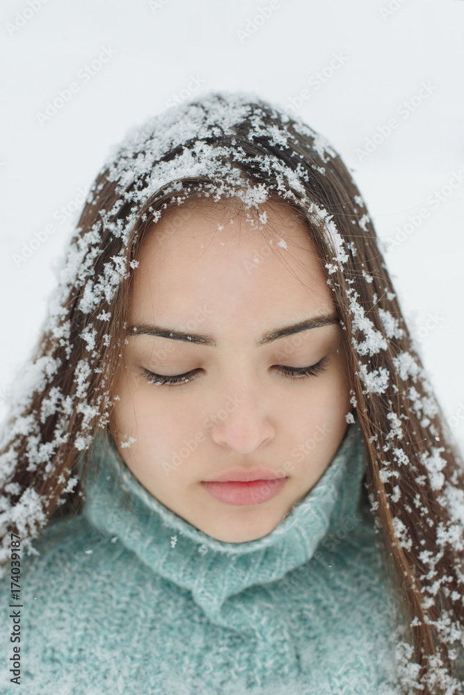 Portrait of a beautiful girl covered with fresh fallen snow in her hair Portrait of a beautiful girl covered with fresh fallen snow in her hair