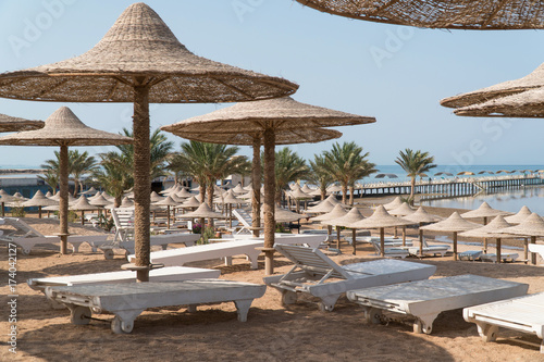 The beach with umbrellas and sun beds  which are empty