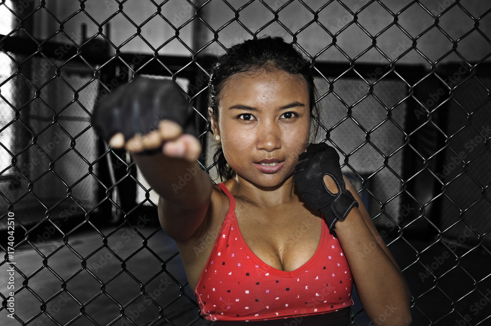 sexy Asian fighter woman in fighting gloves and sport clothes inside