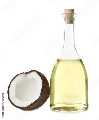 Bottle with fresh coconut oil and nut on white background