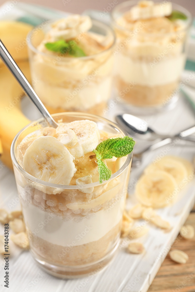 Glass with delicious banana pudding on wooden board Glass with delicious banana pudding on wooden board